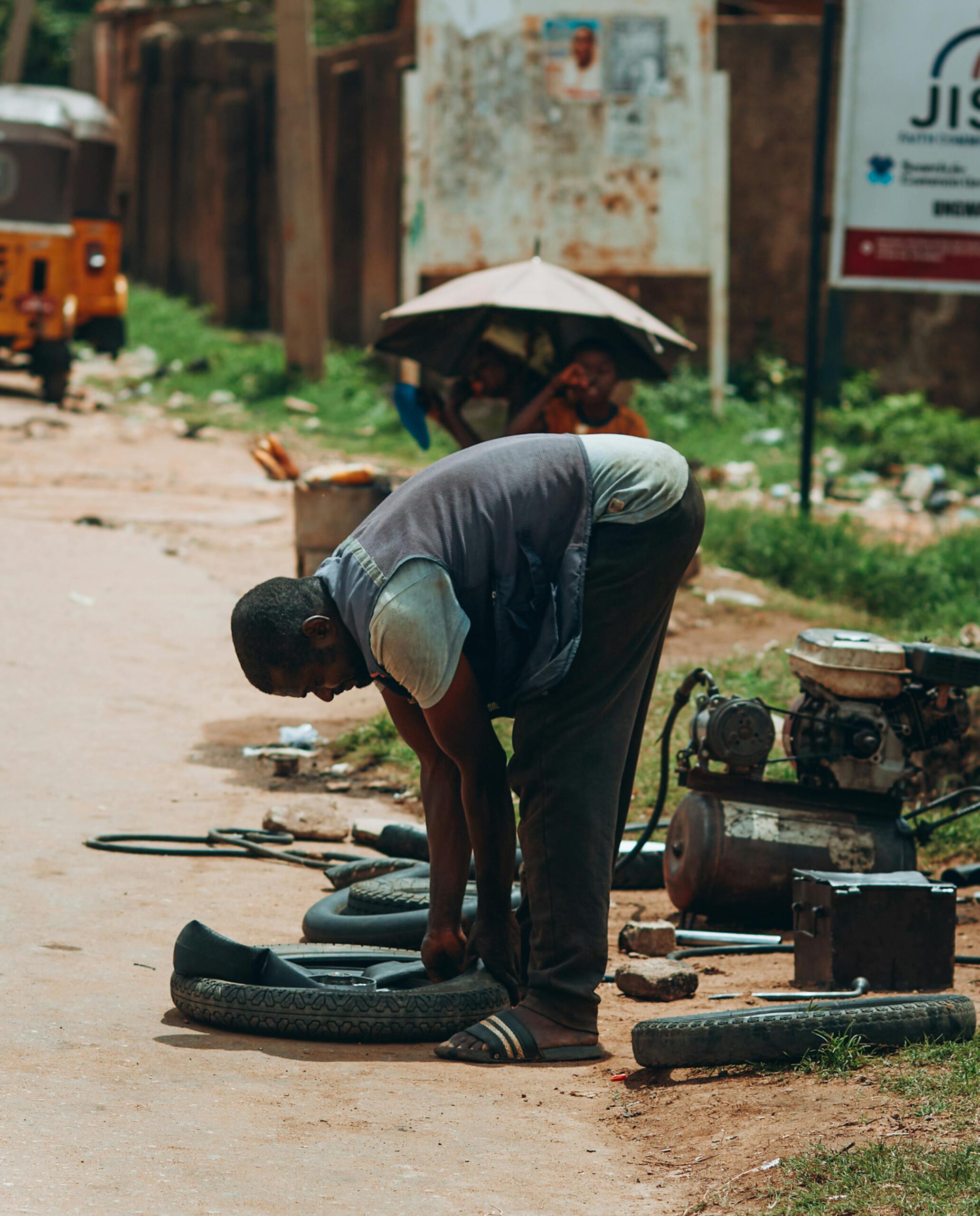 Home Fixing the ride tire ! 💪🔧 This hardworking repairman in Arewa Nigeria is gettin' those tires in shape on a dusty street. Got some tools, got some skill, gettin' the job done 🚗💼